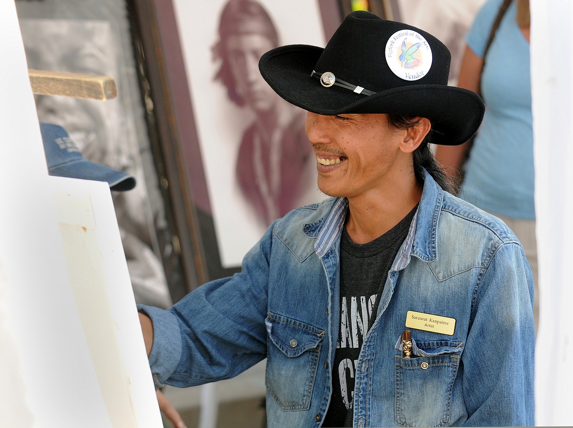 Sarawut Kanpairee, a Thailand charcoal artist does a free-hand charcoal painting in the Sunti World Art Gallery booth at the 38th annual Bigfork Festival of Arts on Saturday. (Aaric Bryan/Daily Inter Lake)