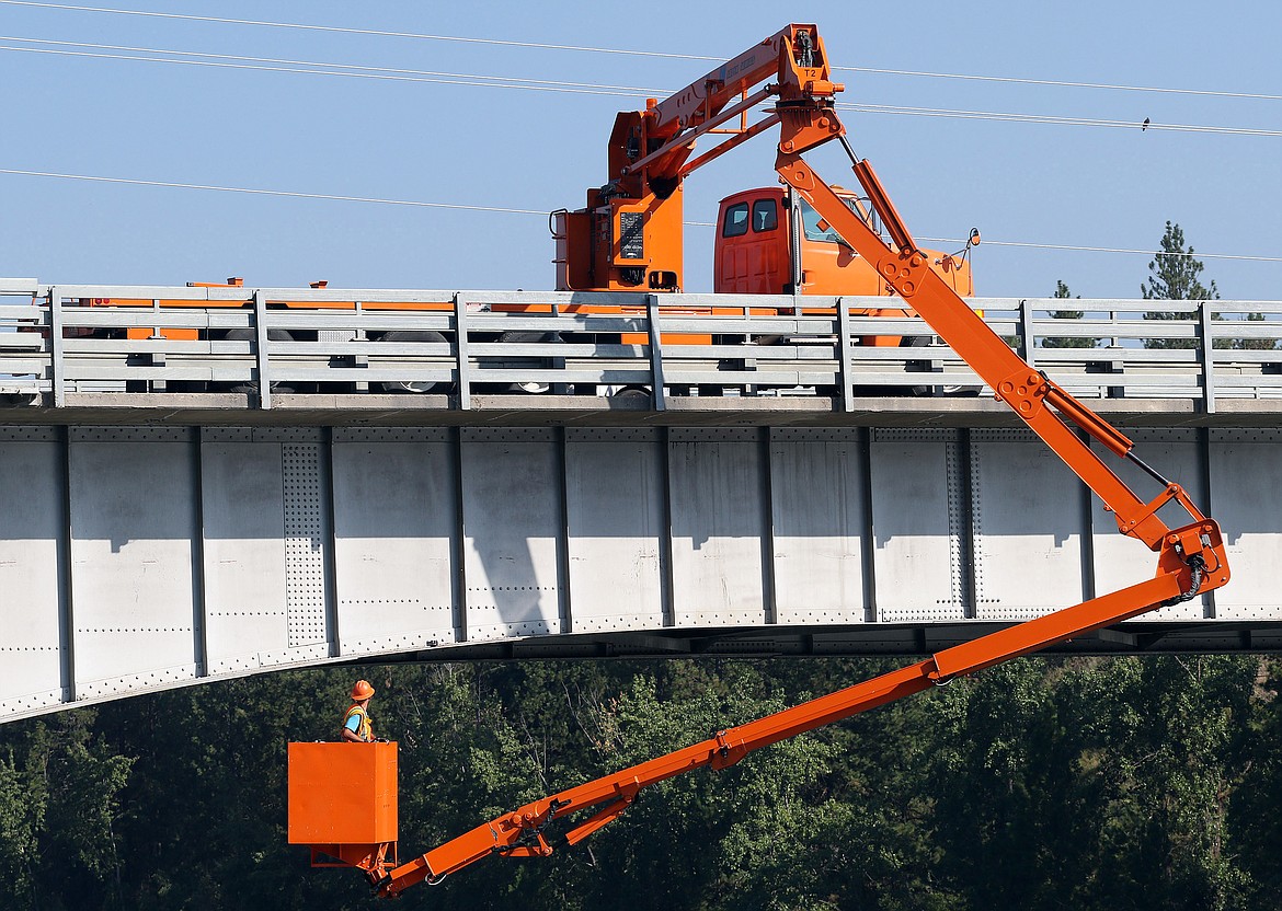 Bruce Liefring of the Montana Department of Transportation inspects the Route 37 bridge in Libby Thursday morning. Bob Vosen, a construction engineer with the department’s District One, said they inspect the bridge — one of 120 in Lincoln County his department oversees — every two years as a matter of routine maintenance. It is in sound shape, he said. Traffic was reduced to one lane of travel at a time during the inspection. (John Blodgett/The Western News)