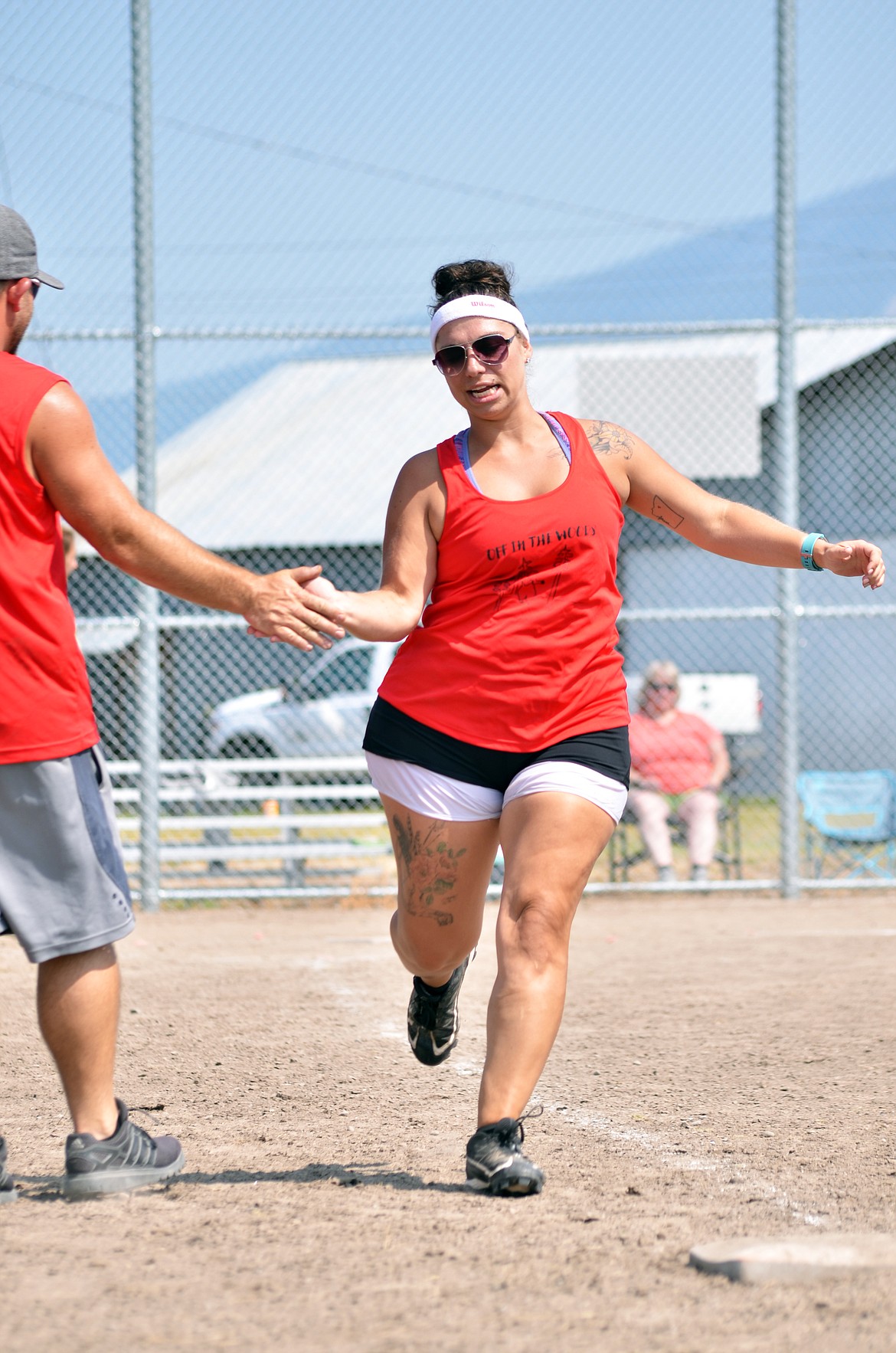 Keaton Jones gets a high five as she gets to first base. (Erin Jusseaume/ Clark Fork Valley Press)