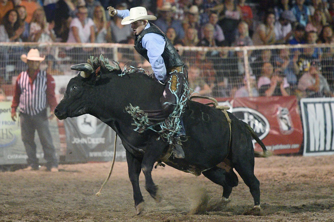 J.T. Moore, of Alvin, TX, holds on to his bull Rapid Fire during the bull riding event at the Northwest Montana Fair PRCA Rodeo on Friday evening at the Flathead County Fairgrounds. (Casey Kreider/Daily Inter Lake)