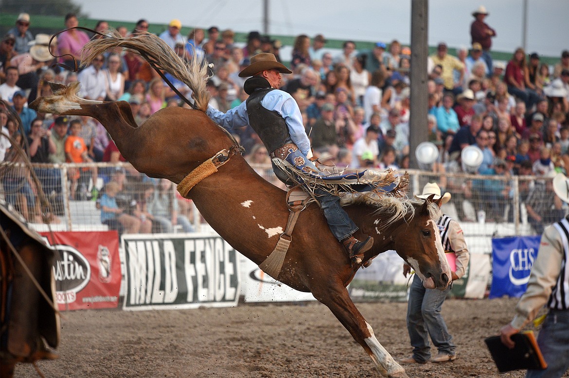 Orin Larsen, of Inglis, Manitoba, Canada, hangs on to his horse Critical Smile during the Bareback Riding event at the Northwest Montana Fair and Rodeo on Thursday. (Casey Kreider/Daily Inter Lake)