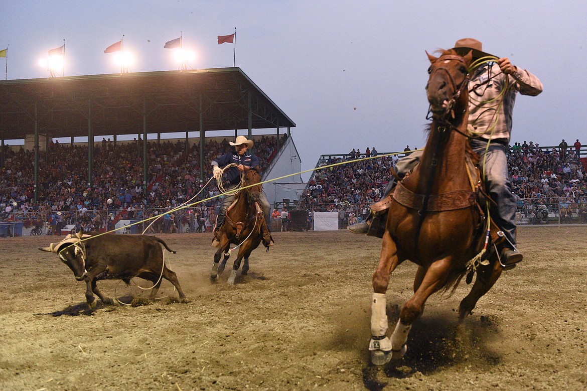 Cody Tew, of Belgrade, and Levi Lord, of Sturgis, South Dakota, compete during the team roping event at the Northwest Montana Fair PRCA Rodeo on Saturday evening at the Flathead County Fairgrounds. (Casey Kreider/Daily Inter Lake)