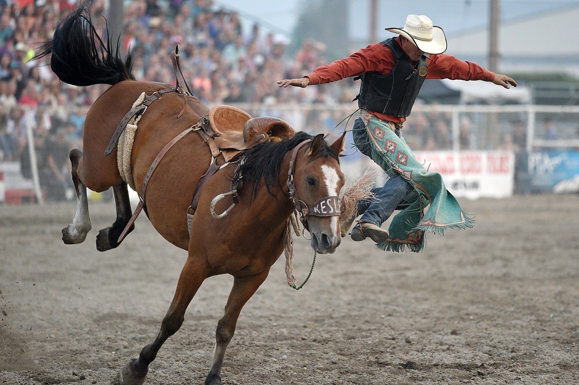 Tanner Hollenback, of Dillon, gets bucked off his horse Trail Smoke during the saddle bronc riding event at the Northwest Montana Fair PRCA Rodeo on Saturday evening at the Flathead County Fairgrounds. (Casey Kreider/Daily Inter Lake)