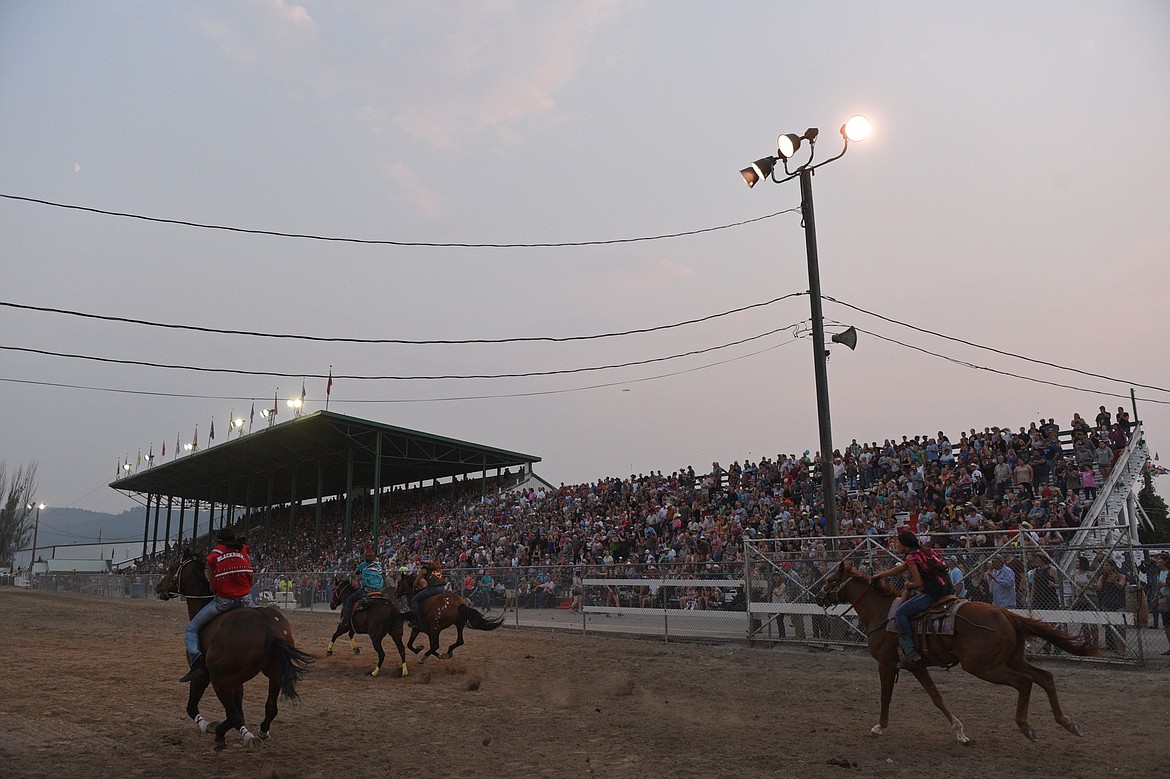 Riders race during the Indian Relay Races at the Northwest Montana Fair PRCA Rodeo on Saturday evening at the Flathead County Fairgrounds. (Casey Kreider/Daily Inter Lake)