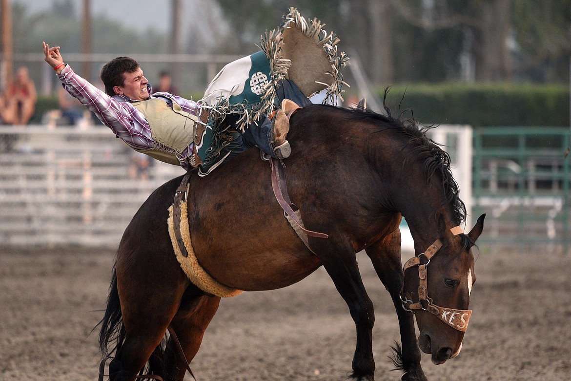 Trevar McAllister, of Polson, hangs on to his horse Mile Away during the Bareback Riding event at the Northwest Montana Fair and Rodeo on Thursday. (Casey Kreider/Daily Inter Lake)