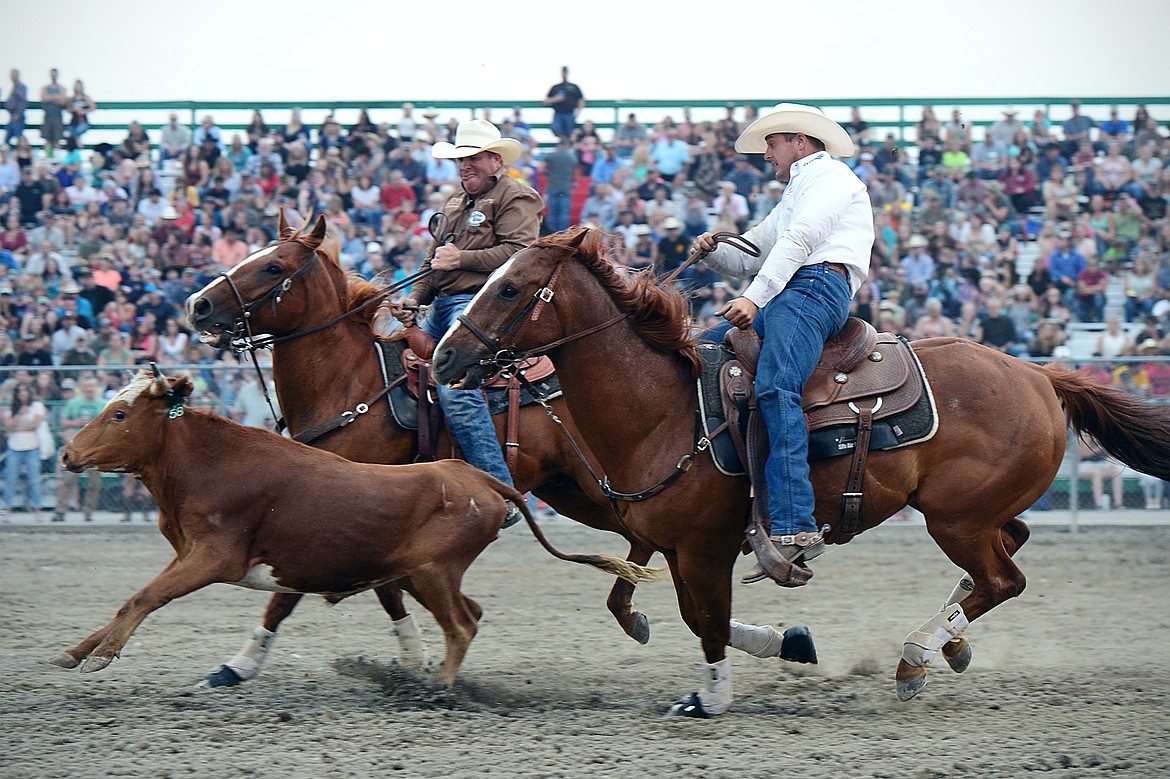 Trevor Knowles, right, of Mount Vernon, OR, pursues a steer during the steer wrestling event at the Northwest Montana Fair PRCA Rodeo on Friday evening at the Flathead County Fairgrounds. (Casey Kreider/Daily Inter Lake)