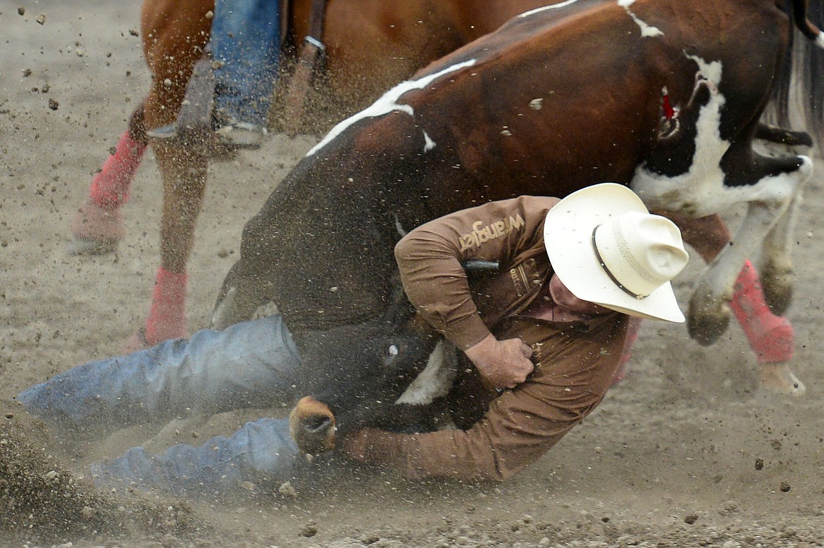 Tanner Milan, of Cochrane, AB, competes in the steer wrestling event at the Northwest Montana Fair PRCA Rodeo on Friday evening at the Flathead County Fairgrounds. (Casey Kreider/Daily Inter Lake)