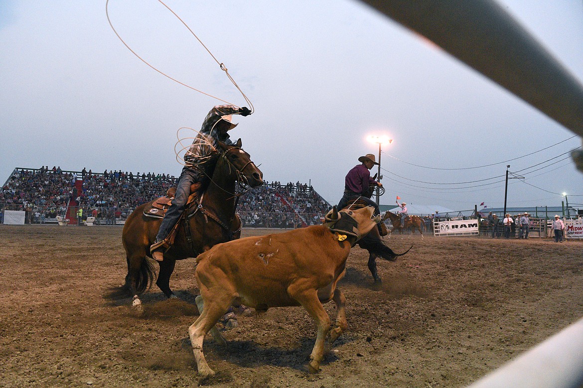 Jack Graham, of Lakeview, Oregon, and Sam Levine, of Wolf Creek, compete during the team roping event at the Northwest Montana Fair PRCA Rodeo on Saturday evening at the Flathead County Fairgrounds. (Casey Kreider/Daily Inter Lake)