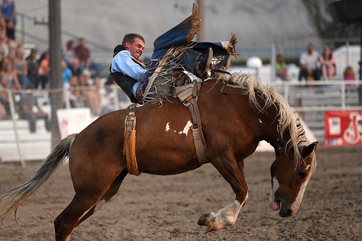 Orin Larsen, of Inglis, Manitoba, Canada, hangs on to his horse Critical Smile during the Bareback Riding event at the Northwest Montana Fair and Rodeo on Thursday. (Casey Kreider/Daily Inter Lake)