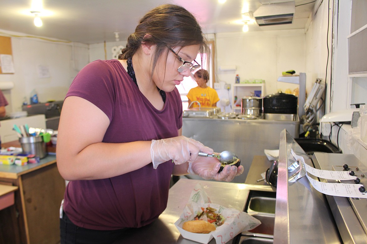 Cheryl Schweizer/Columbia Basin Herald

Laurissa Martinez adds the avocado to a torta at the food booth sponsored by the youth group at Our Lady of Fatima Catholic Church. The youth group uses the money raised for its projects, just like other non-profit booths at the fair.