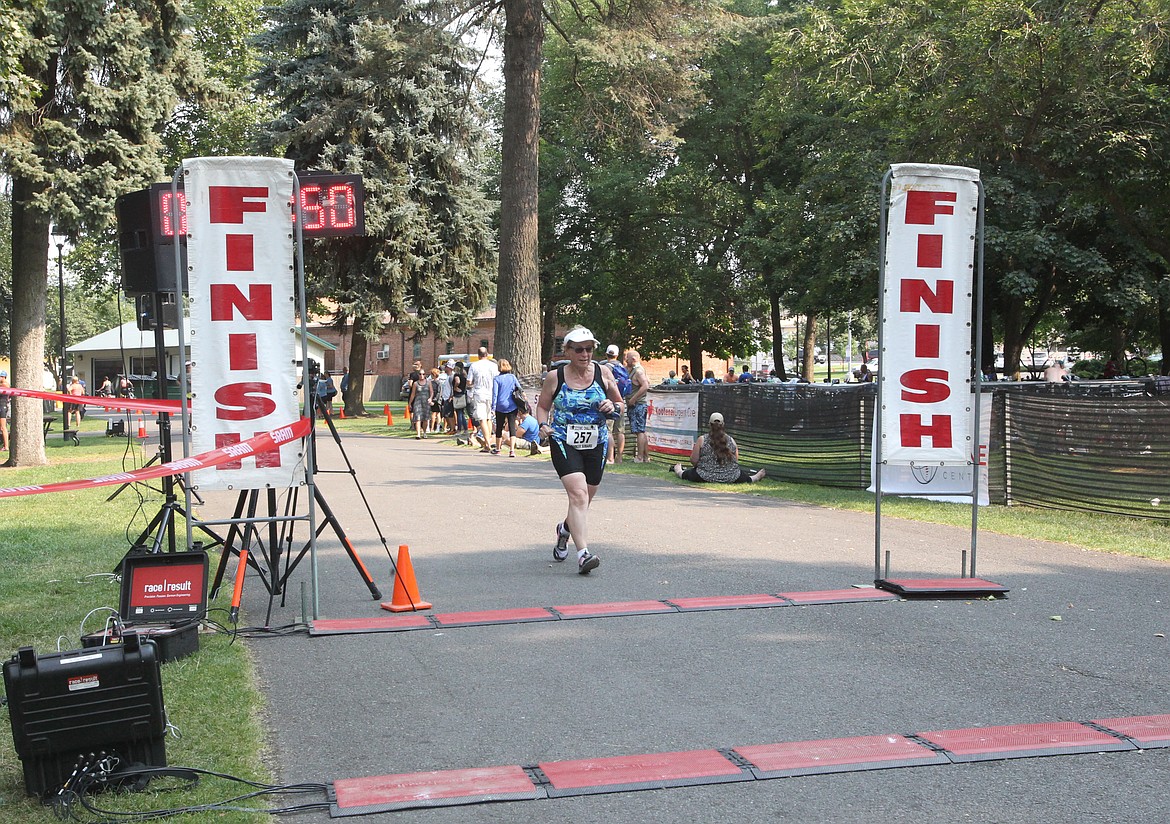 Nancy Haler, 69, of Coeur d&#146;Alene, rushes to the finish Saturday in Coeur d&#146;Alene City Park during the 34th annual Coeur d&#146;Alene Triathlon. Haler participated in the Scenic Sprint, which is half the distance of the Olympic distance race. The Scenic Sprint was added to the Coeur d&#146;Alene Tri in 2013. (DEVIN WEEKS/Press)