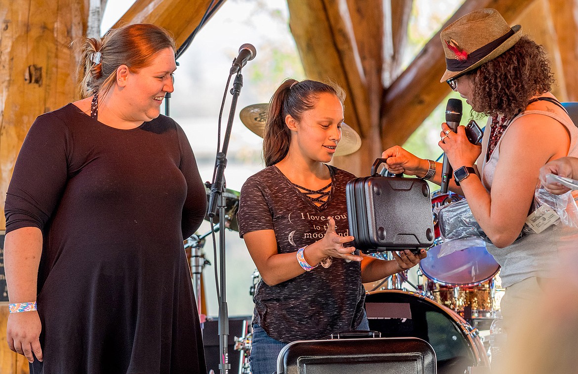 Festival emcee Suze Sims, right, gives a new clarinet to Troy student Shayann Cecelio as her music teacher Sherri Hand watches Aug. 11.