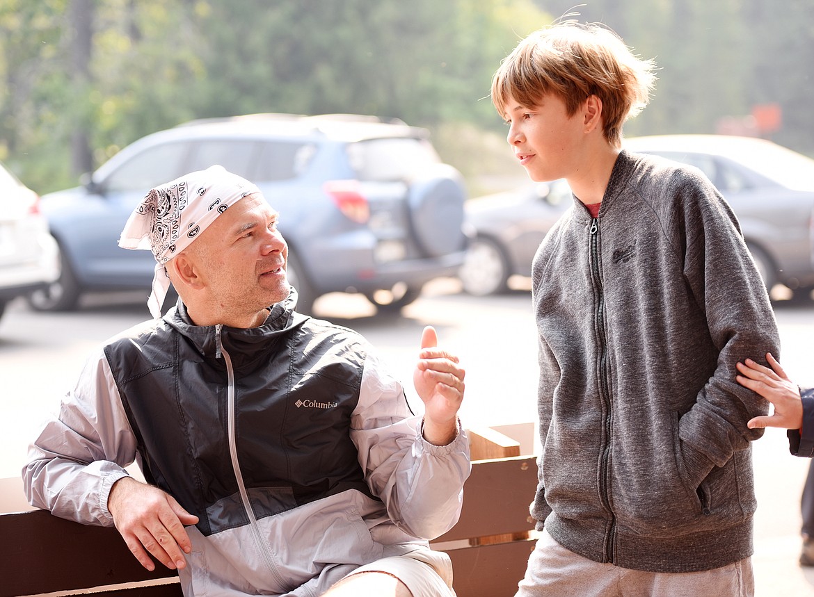 Gabriel Stachura of Queens, New York, and his twelve-year-old son Jules wait for the rest of the family as they order ice cream cones in Glacier National Park on Monday, August 13.&#160;(Brenda Ahearn/Daily Inter Lake)