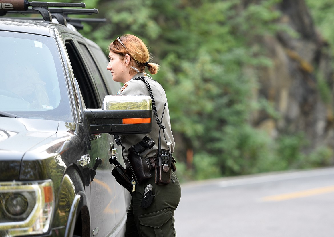 Park Ranger Elizabeth Boyden talks with a visitor at the intersection of Apgar Loop and Going-to-the-Sun Road in Glacier National Park on Monday, August 13. Visitors had to be stopped at Apgar and rerouted either to East Glacier, from which visitors can still reach Logan Pass, or toward North Glacier.(Brenda Ahearn/Daily Inter Lake)