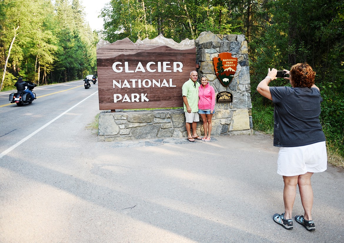 Bobbie Miller of Mt. Airy, Maryland takes a photo of Laurie and Dave Dunshee at the sign at the entry to Glacier National Park at West Glacier on Monday, August 13. Miller and her family have a summer home in Columbia Falls. The Dunshee&#146;s are visiting from Hollywood, Florida.
(Brenda Ahearn/Daily Inter Lake)