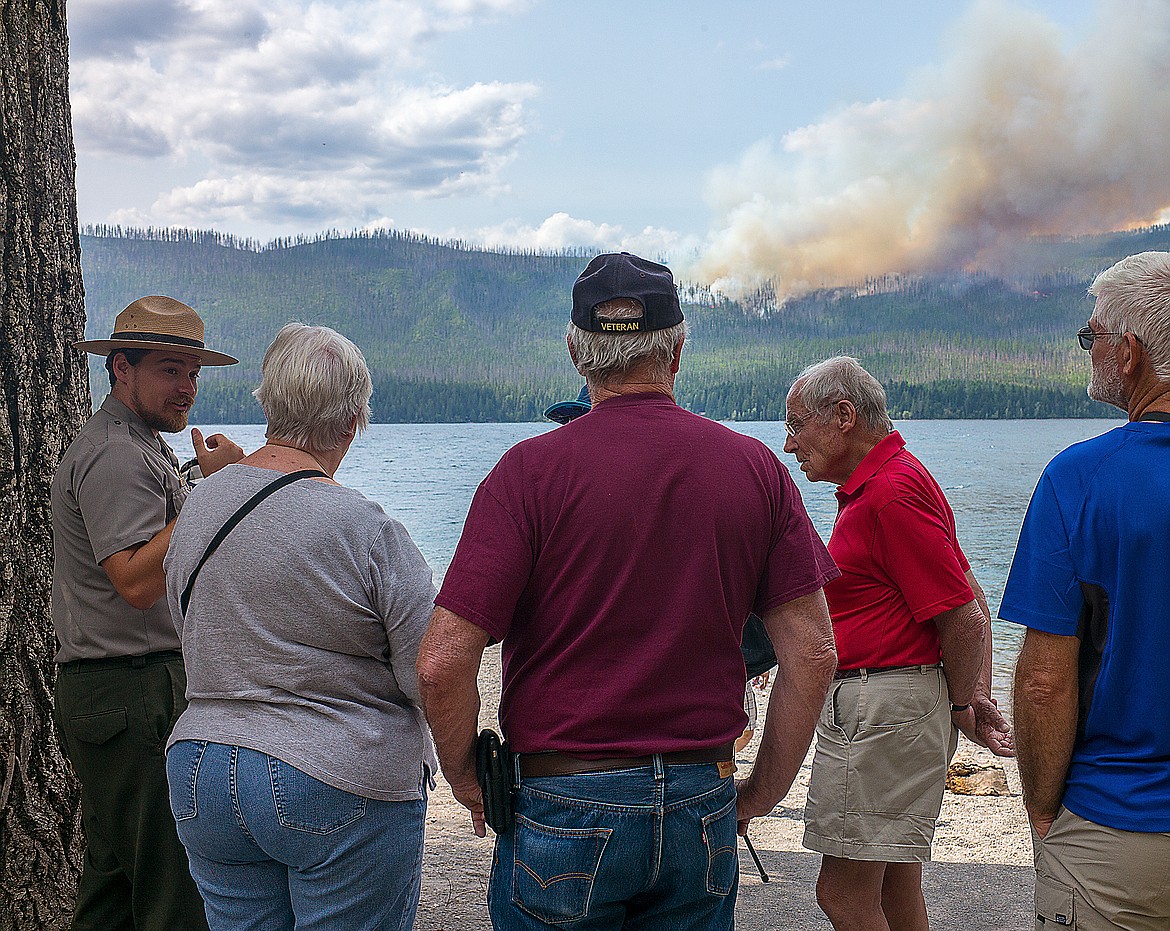 Interpretative ranger Steve Thompson, left, talks about the Howe Ridge Fire with visitors at the Lake McDonald Lodge.