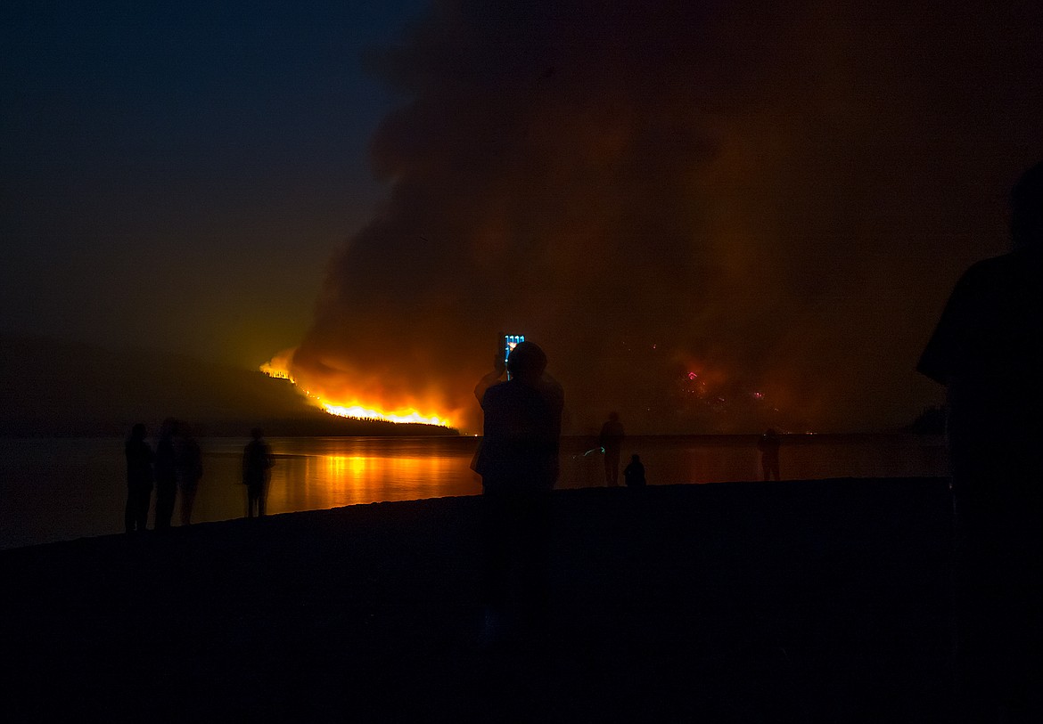 Gail Pauley uses her tablet to take a picture of the Howe Ridge Fire in Glacier National Park Sunday.