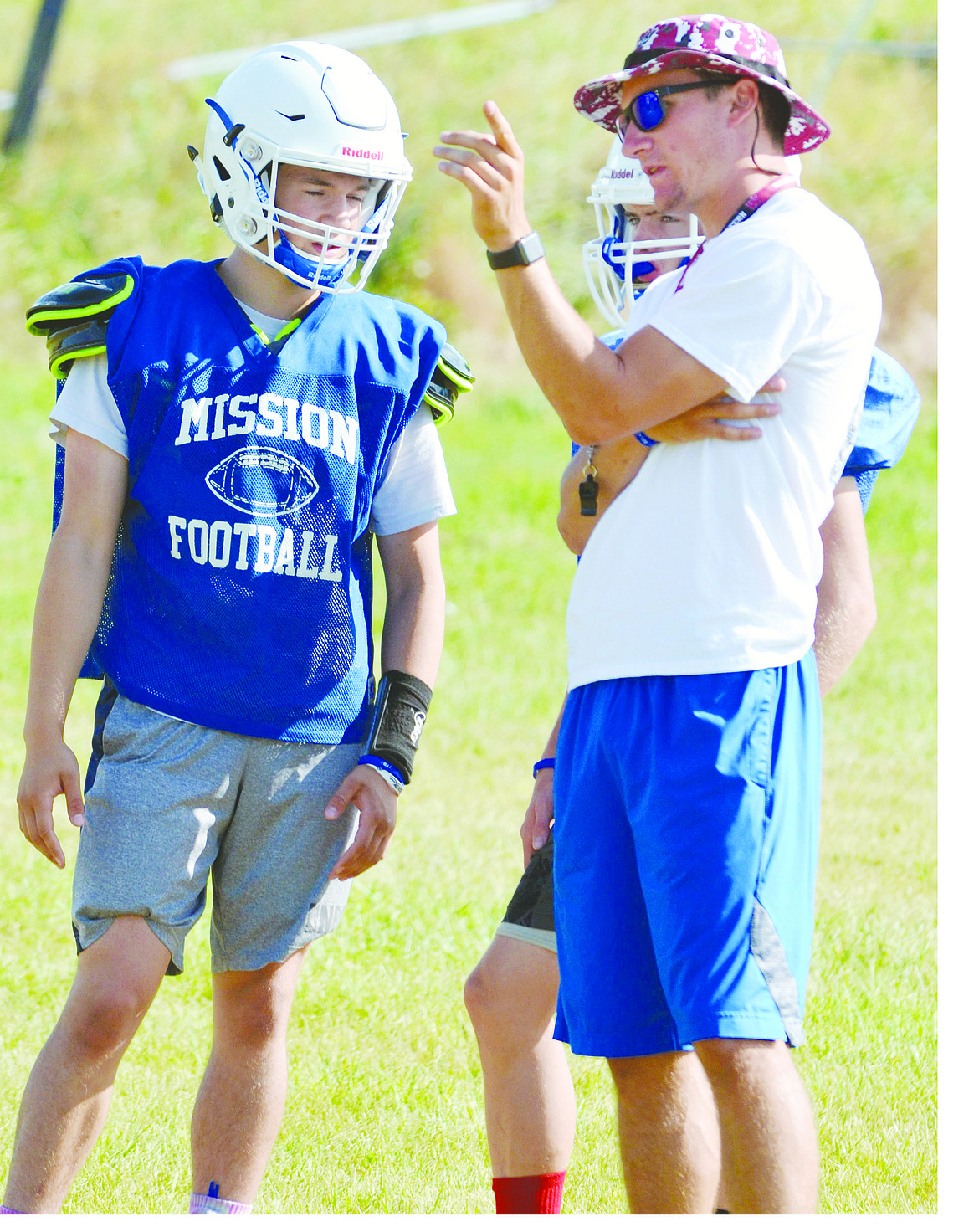 MISSION HIGH School football coach Tyler Murray (right) talks to potential starting varsity quarterback Isaac DuMontier (left) during the Bulldogs&#146; camp. Murray, who will enter his second season at head coach after graduating from Western Montana, hopes to qualify for the Montana High School Association Class C 8-man football playoffs, after narrowily missing the playoffs last season with a 4-5 record in the Bulldogs&#146; first-ever season in Class C. (Jason Blasco/Lake County Leader)