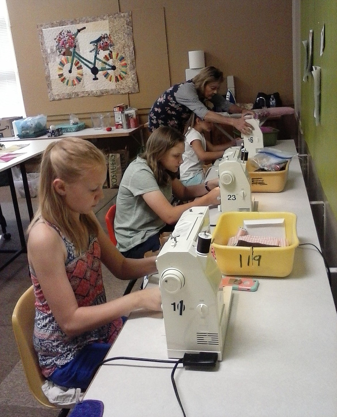 Paula Darko-Hensler instructs, from back, Claire Fantozzi, Raven Voss and Sophia Kim during a sewing boot camp the Kootenai Valley Quilt Guild held at Asa Wood School in Libby from Aug. 6-9. (Courtesy photo)