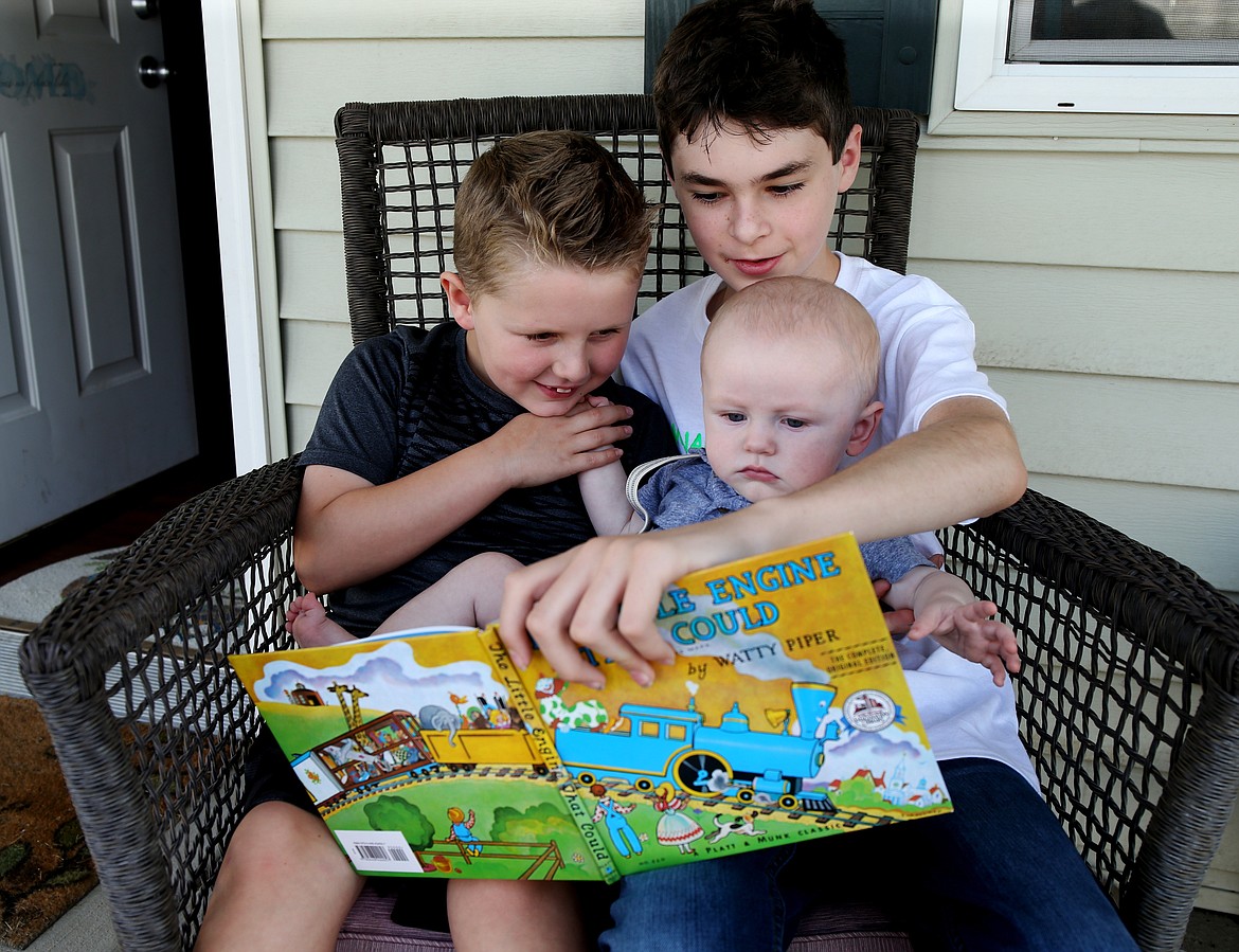 Photos: LOREN BENOIT/Press 
Breckin Willoughby, 7, left, Ayden Alderman, 11, and Hunter Willoughby, 7 months, read &#147;The Little Engine That Could,&#148; the first book that is mailed to kids who take part in MONARCH TRAIN.