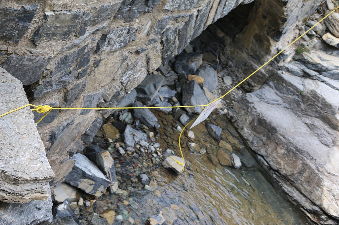 The entrance to the culvert that carries Haystack Creek under Going-to-the-Sun Road is roped off after a 15-year-old Idaho boy slipped and fell to his death there July 31.