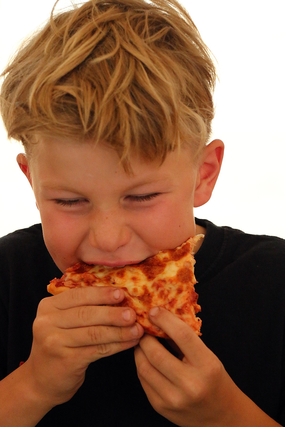 (Photo by CAROLINE LOBSINGER)Weston Lake chows down on a piece of pizza en route to a first-place finish during an pizza eating contest at the Bonner County Fair on Thursday.