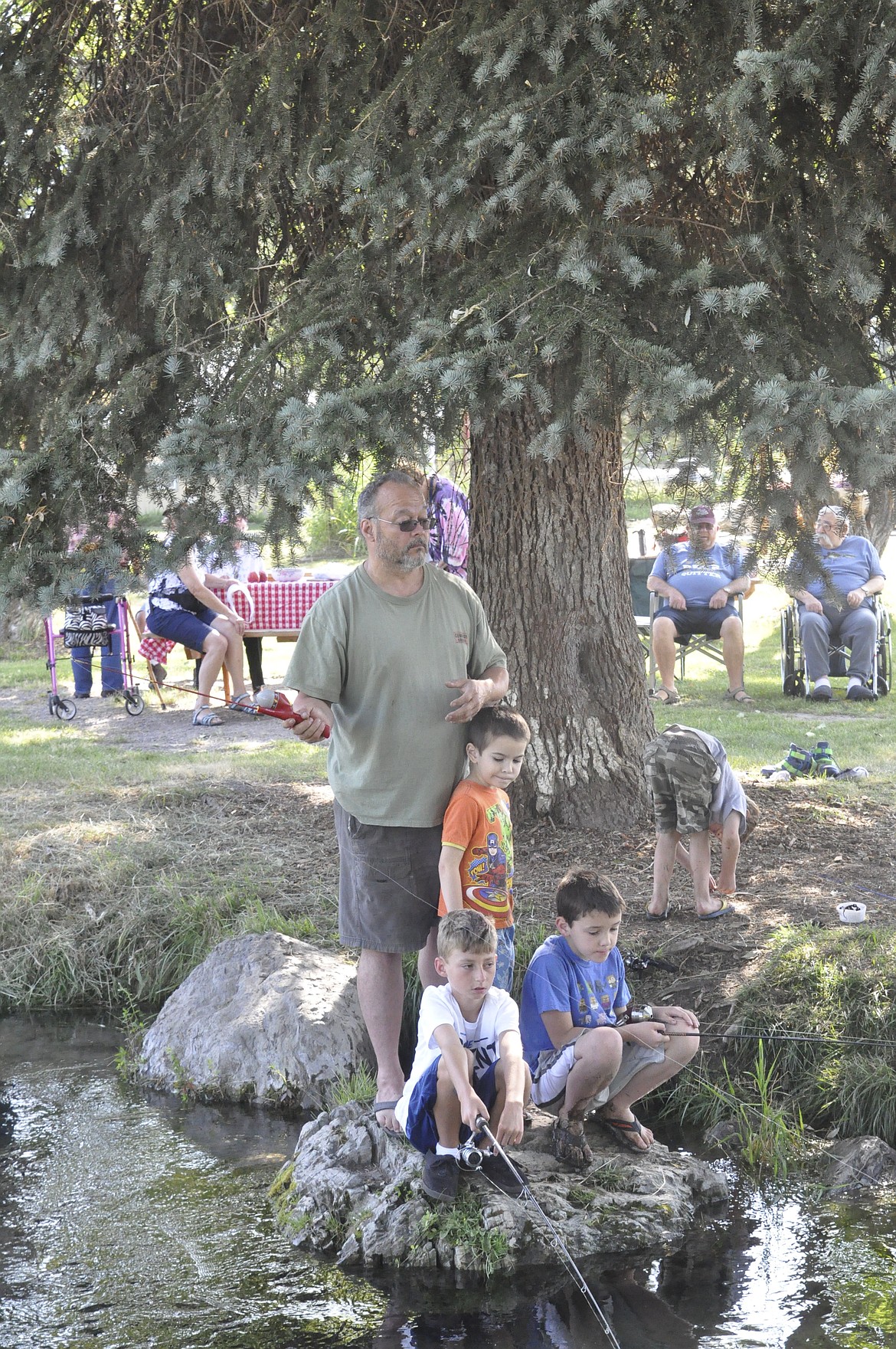 CLOCKWISE FROM TOP are Robert Broughton, Samuel, 6, and David, 9, along with a friend the boys made at fishing derby held at RONAN PARK Friday, Aug. 3. (Ashley Fox/Lake County Leader)