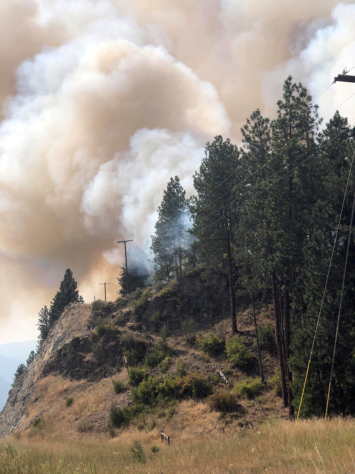 The fire quickly moved up the rock ridge through the forest as firefighters scrambled to get around the front of it. (Erin Jusseaume/Clark Fork Valley Press)