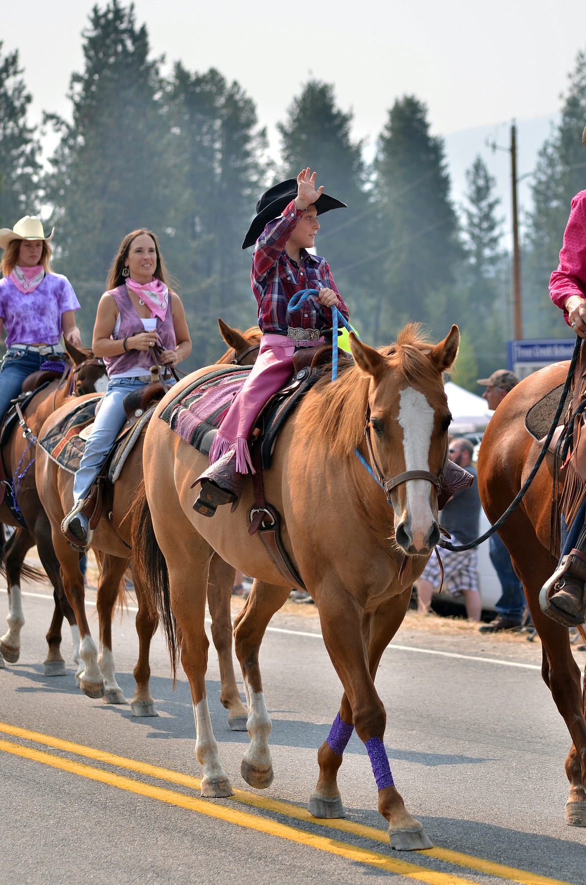 Riders from the Back Country Horsemen were all smiles waving as they rounded up the 39th Huckleberry Festival Parade. (Erin Jusseaume/ Clark Fork Valley Press)
