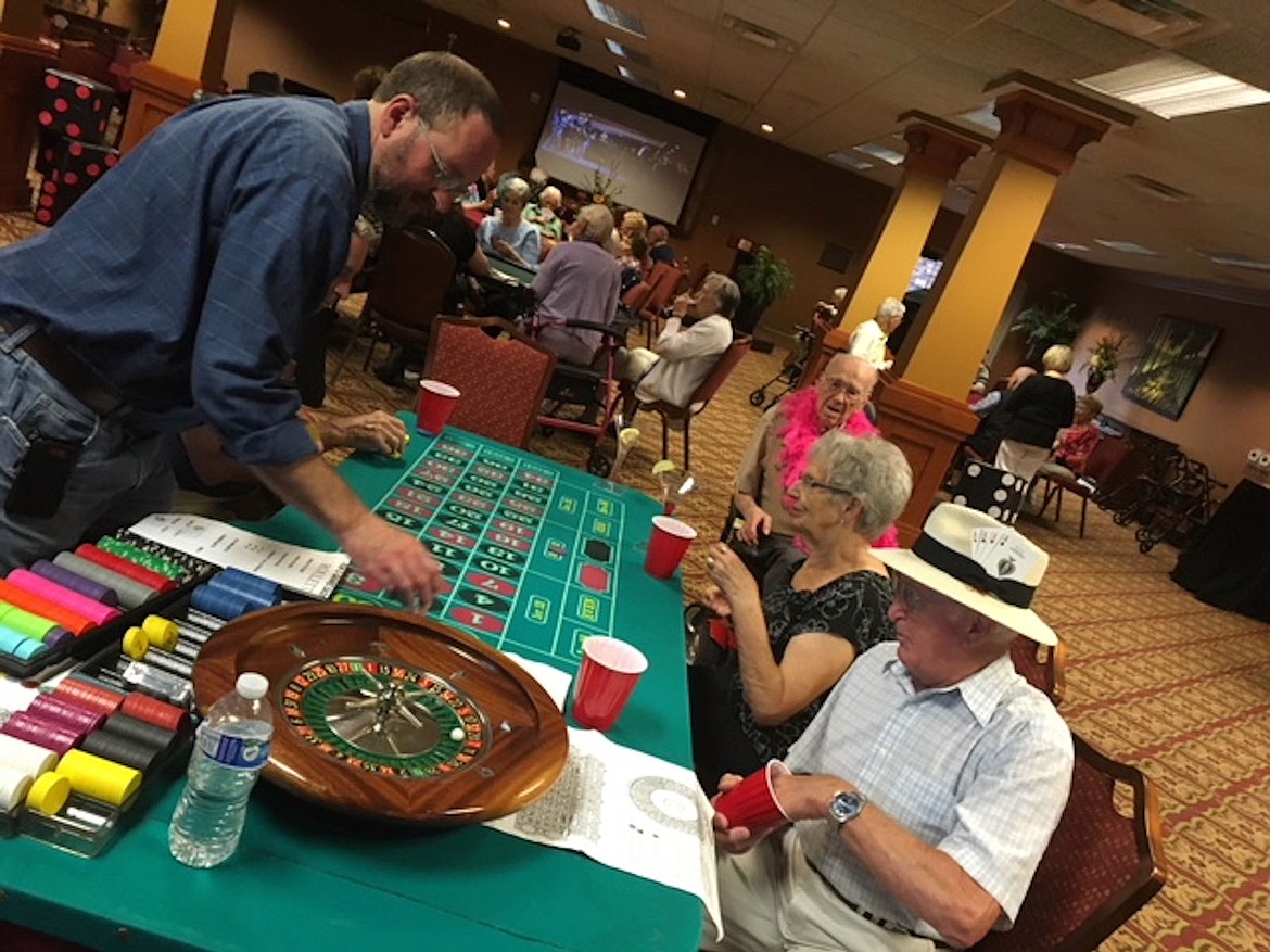 Courtesy photo
Carla Radford and Joe Reis test their luck as Roland Rueber, owner of Aspen Meadows B &amp; B, volunteers to run a game table on Casino Night at Garden Plaza.