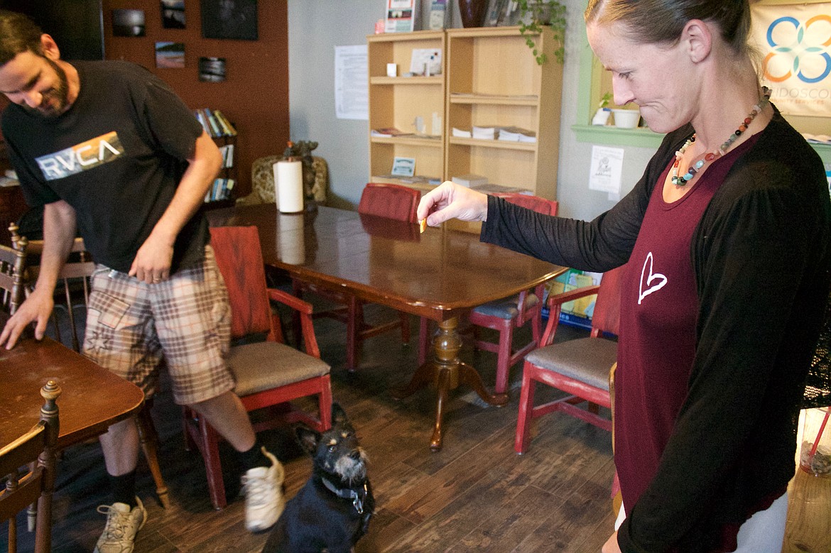 Lacey Thompson gives her dog, Nox, a treat at 2nd Street Commons while Ryan Peppers looks on.