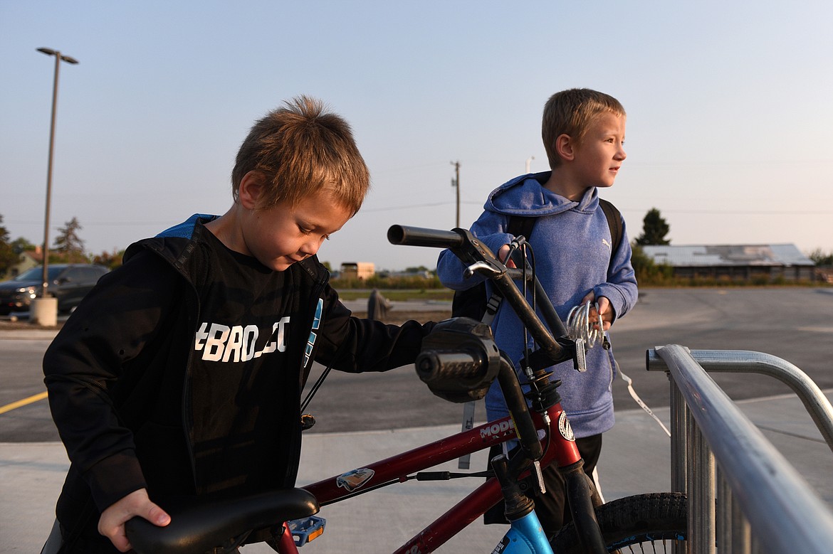 First-grader Kyler Kubai, left, and his brother Kayvis, a third-grader, lock up their bikes before the first day of school at Rankin Elementary School in Kalispell on Wednesday. (Casey Kreider/Daily Inter Lake)