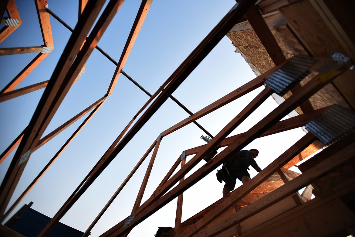 Ryan Hargrave is silhouetted against the morning sky as he works on an Iron Star Construction site in north Kalispell on Thursday morning, August 23.(Brenda Aheran/Daily Inter Lake)