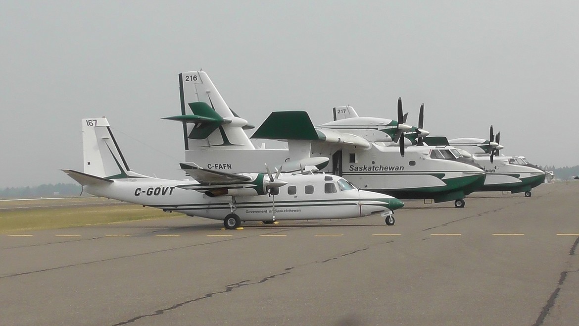 A fleet of planes from the government of Saskatchewan sit at Glacier Park International Airport Saturday afternoon. The plane in the foreground is a craft that fire professionals call a &#147;Bird-dog&#148; because it surveys a wildfire and helps guide water drops from the larger CL-215s, popularly known as &#147;Super Scoopers.&#148; The team has been in Northwest Montana for a few weeks helping ground crews control wildfires burning in Glacier National Park as well as the Flathead and Kootenai National Forests. (Scott Shindledecker photos/Daily Inter Lake)