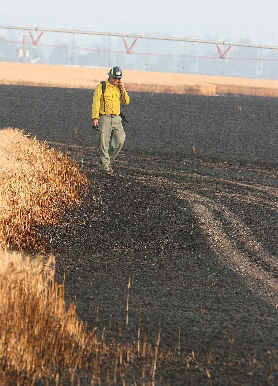 Idaho Department of Lands firefighter Josh Lander makes his way back to a truck after battling a wheat field fire east of Highway 41 on Tuesday evening.

BRIAN WALKER/Press