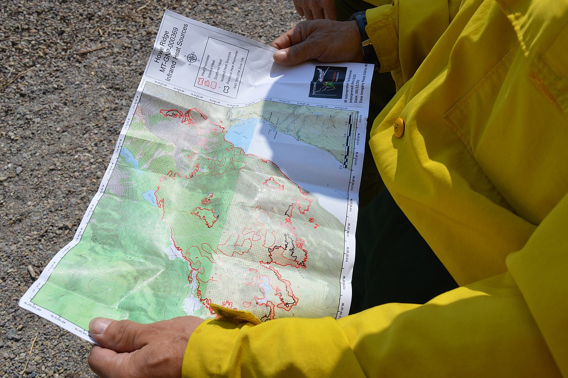 Firefighter Kyle Johnson looks over the Aug. 22 infrared map of the 10,300-acre Howe Ridge Fire.