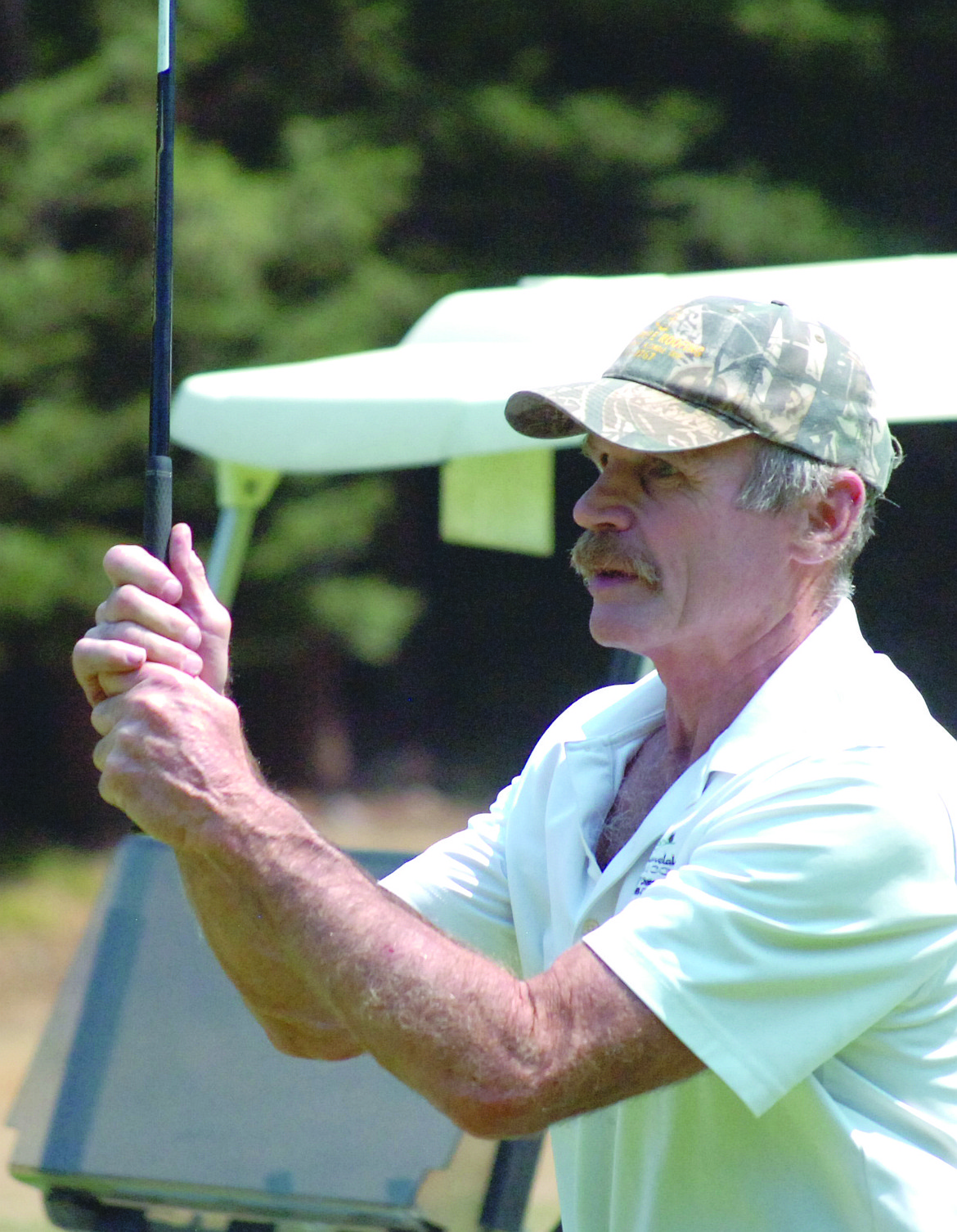John Watson keeps an eye on his fairway shot during Avista&#146;s 10th Annual Charity Golf Scramble and Silent Auction. Net proceeds from the tourney went to benefit Western Montana Mental Health.
