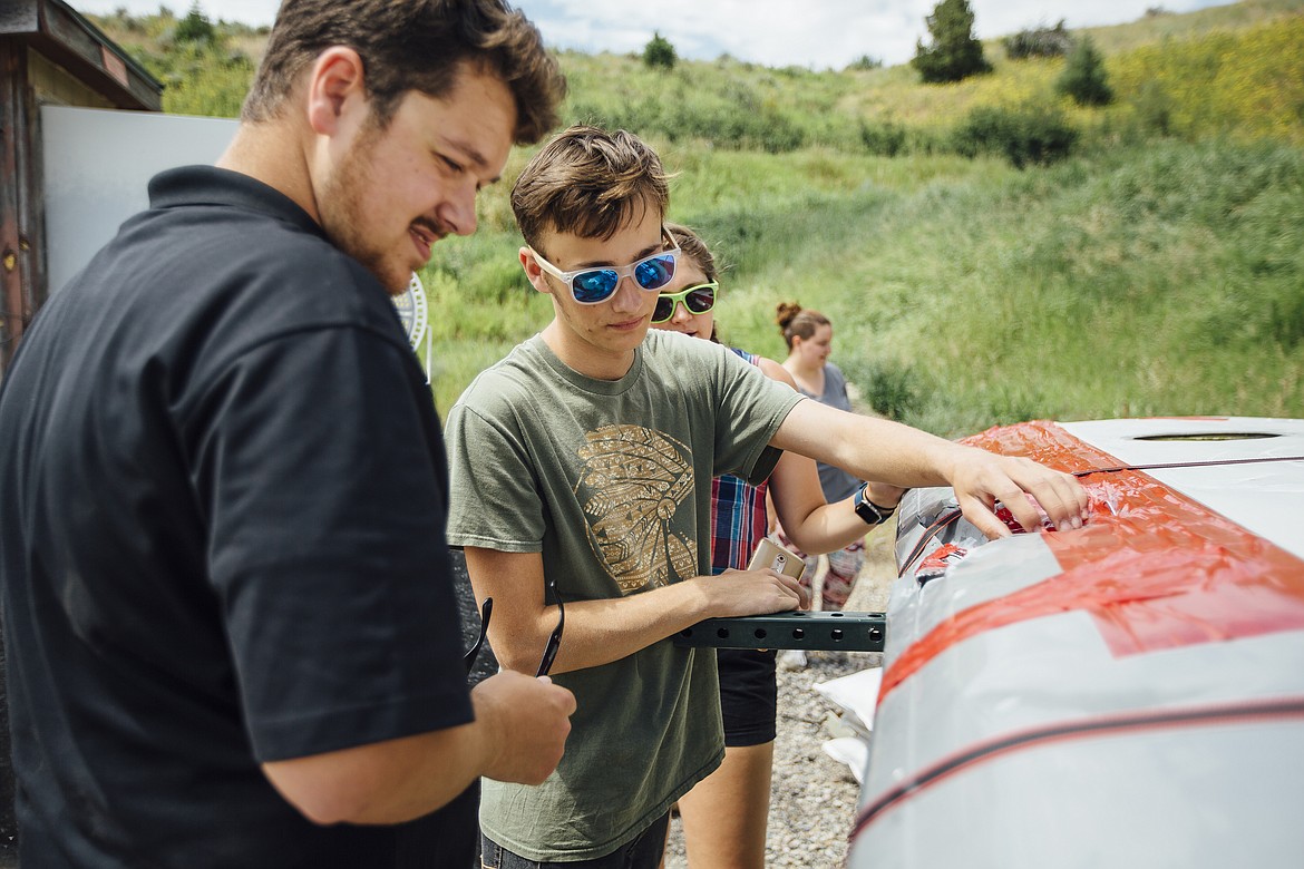 Raferdy Samson of Hot Springs, center, a high school senior in the Montana Apprenticeship Program (MAP), inspects the damage to a light airplane wing during a drone project along with Mike Reininger from the Federal Aviation Administration, left, and Madison Tandberg, an undergraduate in mechanical engineering at Montana State University, Led by MSU professor Doug Cairns, students in MAP run crash tests of small unmanned aerial vehicles at the MSU Fort Ellis Research Farm, near Bozeman. (Photo by Adrian Sanchez-Gonzalez/MSU)