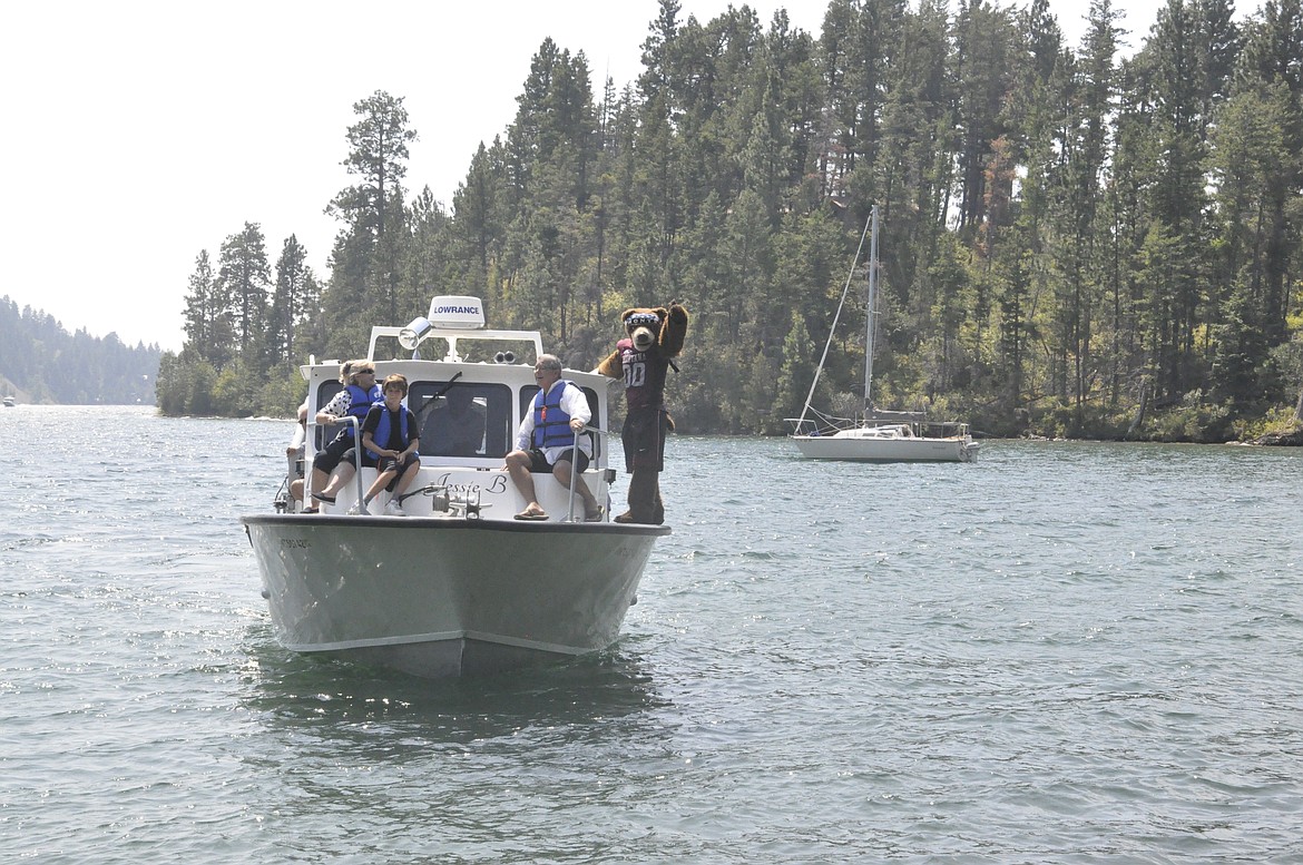 MONTE WAVES from a boat from the Flathead Lake Biological Station back to land Friday, Aug. 3, during an open house the following day. (Ashley Fox/Lake County Leader)