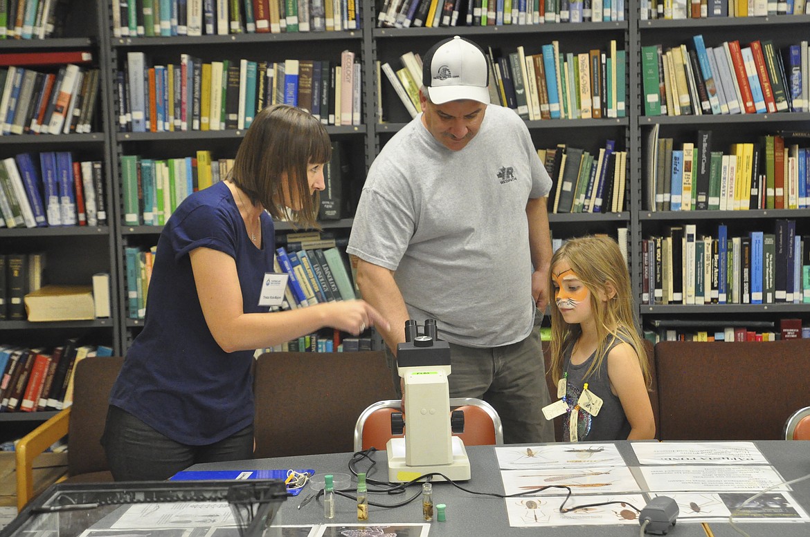 TRISTA VICK-MAJORS, left, explains to Sean and Tristyn Charbot of Bigfork what they&#146;ll see when they look in a microscope. (Ashley Fox/Lake County Leader)