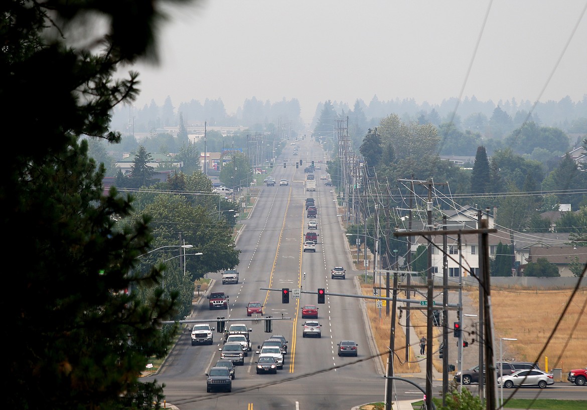 Motorists head east and west on Mullan Avenue in Post Falls under a smoke-filled sky on Monday. (LOREN BENOIT/Press)