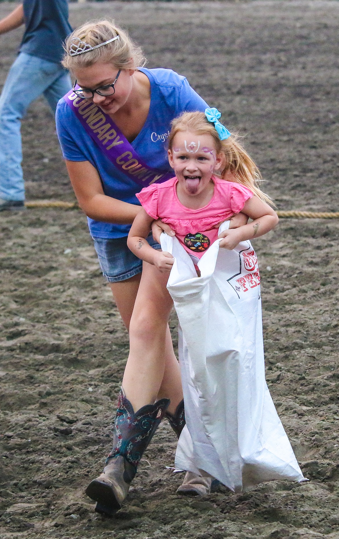 Photo by MANDI BATEMAN
A young competitor gets a helping hand from Fair Royalty during the Sack Race.