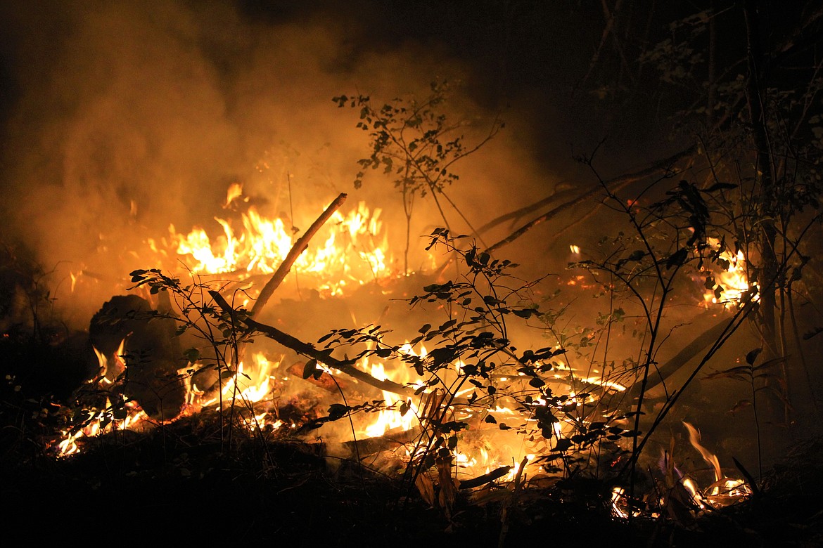 Fire burns up the hillside as crews attempt to limit its reach.