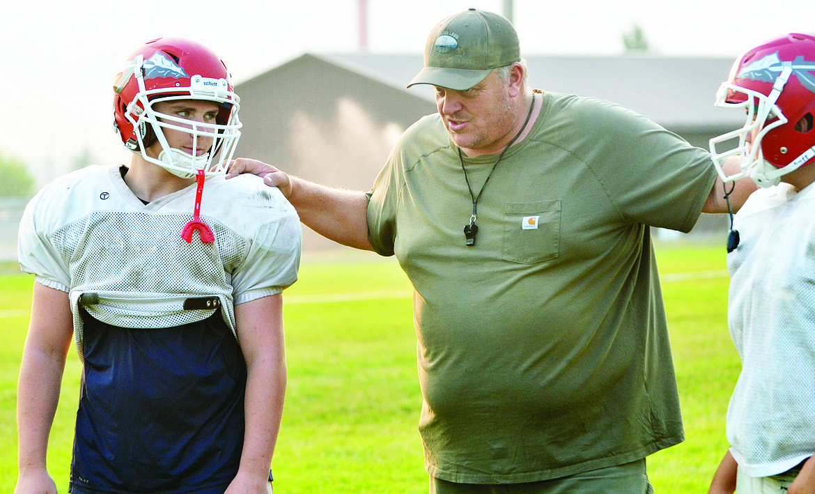 ARLEE HIGH School coach Chuck Forgey (middle) instructs Noah Coulson (left) during the second portion of the Warriors' last two-a-day practice Thursday night at Arlee High School. (Jason Blasco/Lake County Leader)