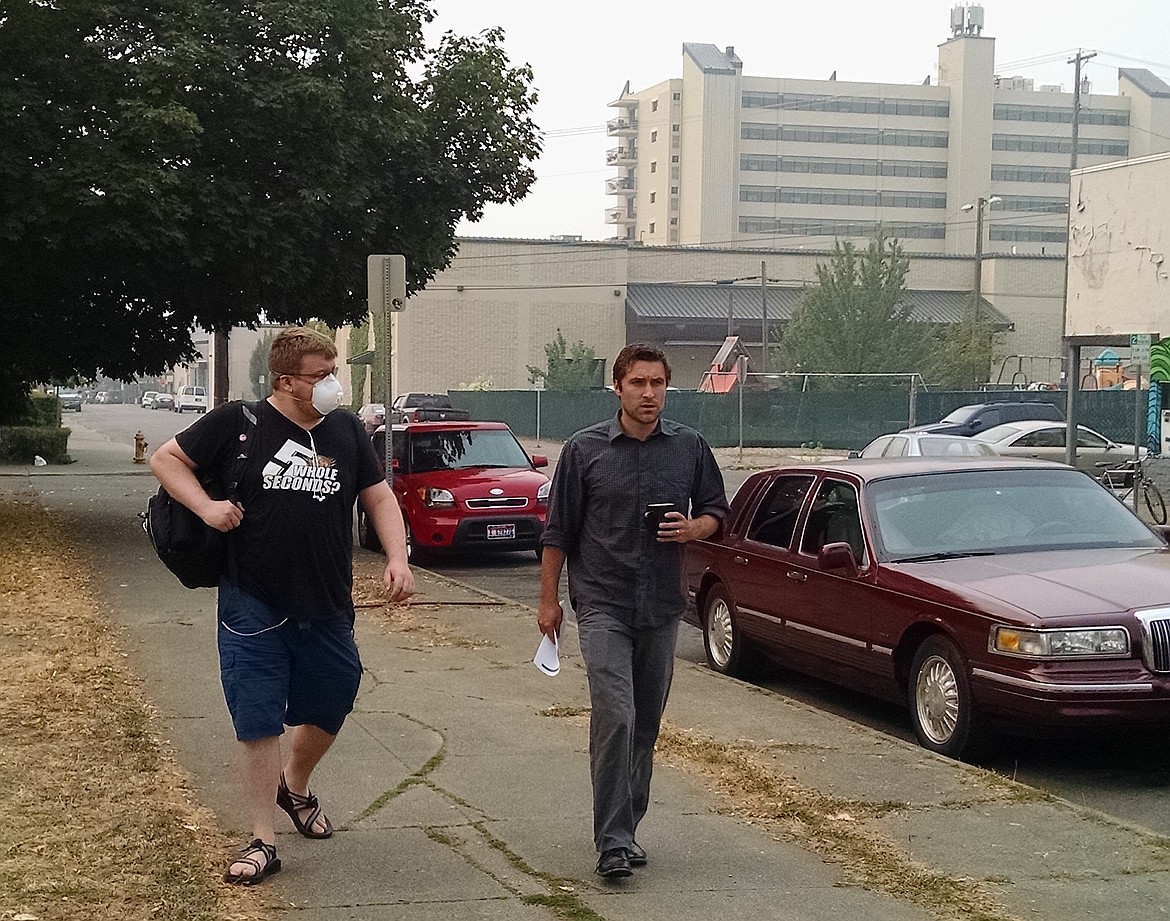 John Warton, left, and Conor Kenna walk to North Idaho College for the first day of classes in Coeur d'Alene on Monday. Respirator masks labeled N95 or N100 with two straps can protect your lungs from wildfire smoke, health experts say. Single-strap paper dust masks, surgical masks, bandanas, towels and tissue do not. (BRIAN WALKER/Press)