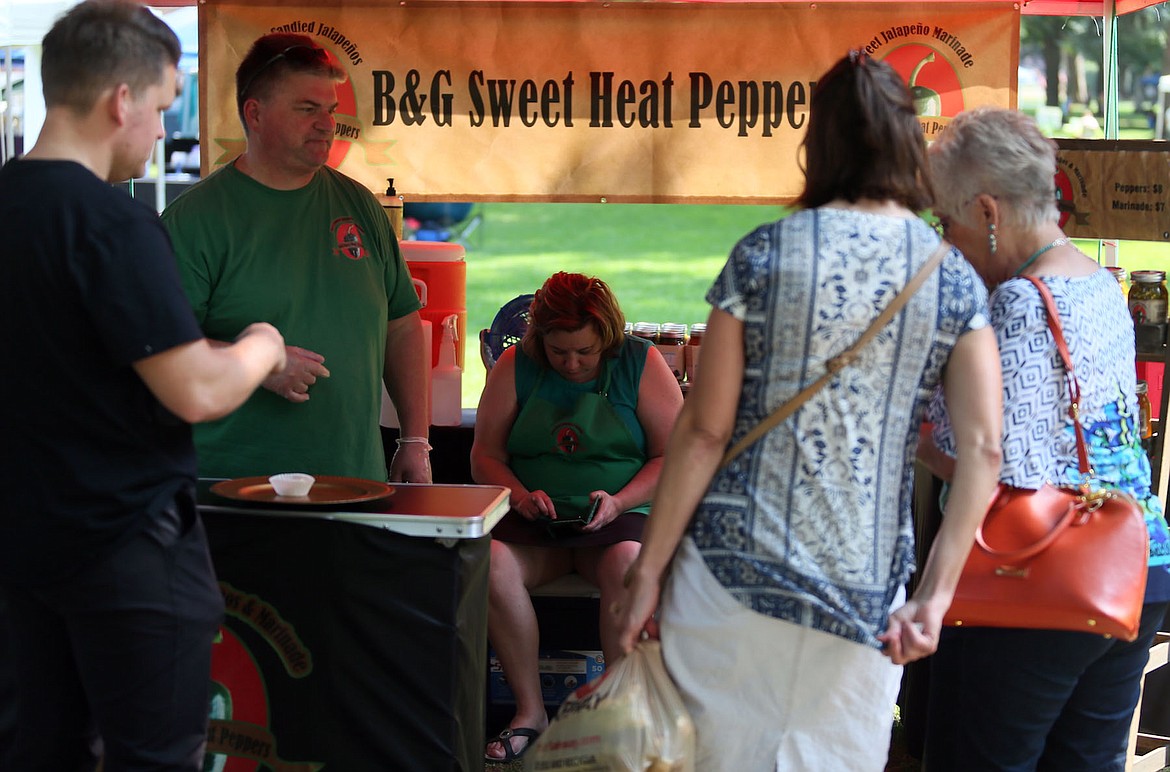 Parkgoers sample Bob and Gail Emmons&#146; candied jalape&ntilde;os at the Choose Local Festival on Saturday. (JUDD WILSON/Press)