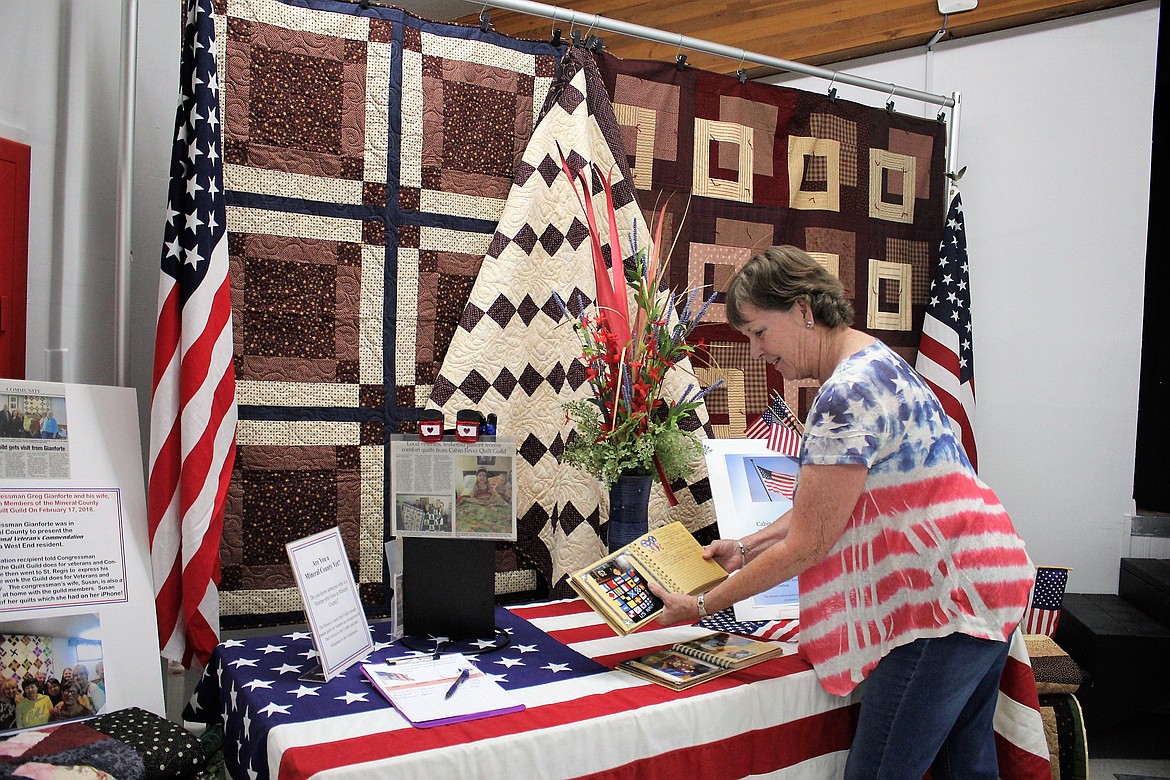 The Cabin Fever Quilters donate quilts to local veterans every year. Member Della Russell puts the final touches on a table where veterans could sign up to receive a quilt of their own.