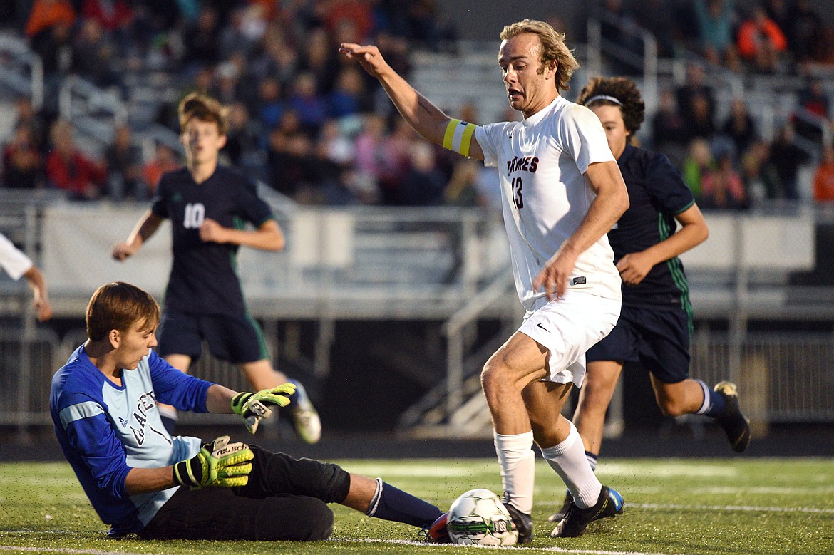 Flathead's Colter Goss (13) works the ball past Glacier goaltender Andrew Lorenc for a goal scored by teammate David Marburger during a crosstown matchup at Legends Stadium on Thursday. (Casey Kreider/Daily Inter Lake)