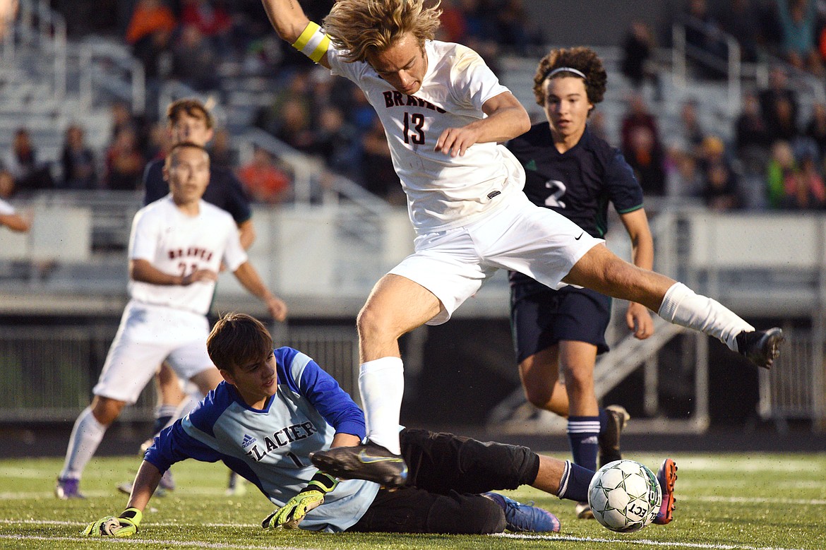 Flathead's Colter Goss (13) works the ball past Glacier goaltender Andrew Lorenc for a goal scored by teammate David Marburger during a crosstown matchup at Legends Stadium on Thursday. (Casey Kreider/Daily Inter Lake)