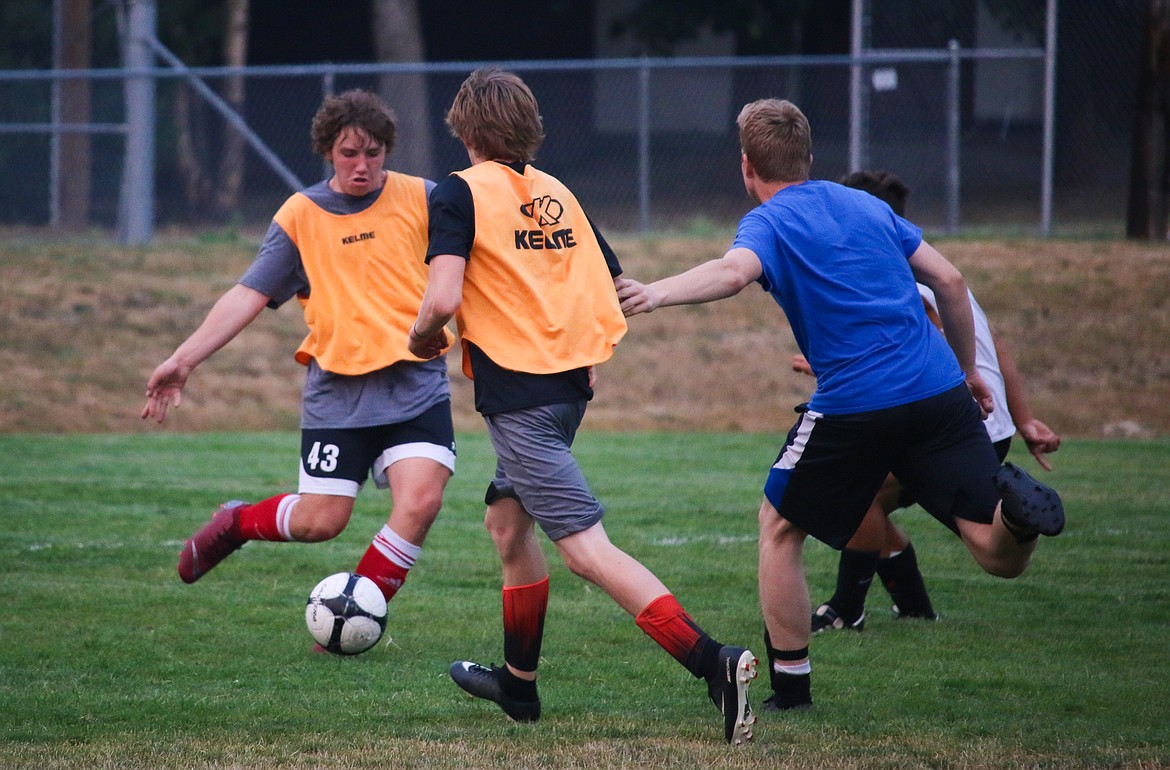 Photo by MANDI BATEMAN
Sophomore Dalin Foster trying to clear the ball before Seth Bateman (in blue) can attack, while Ben Tadlock challenged Seth during the play.